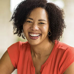 A young woman shows off her teeth after receiving cosmetic dentistry services at Lovett Dental Gulfgate