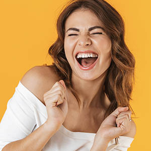 A woman laughs as she thinks about the dental implant services at Lovett Dental Gulfgate