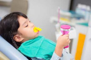 A little girl gets fluoride treatments in TX at a dentist's office 