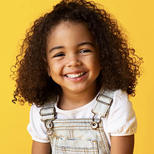 A little girl smiles as her mom tells her about the pediatric services at Lovett Dental in Gulfgate