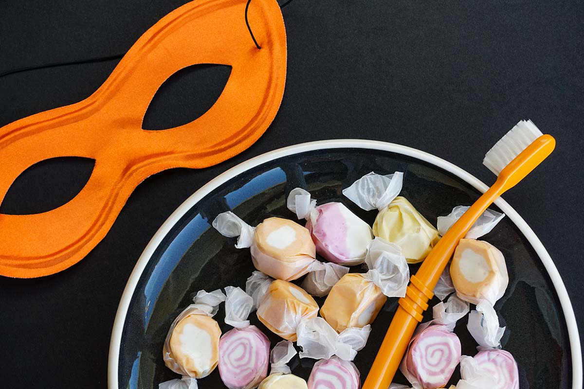 a toothbrush in a bowl of candy makes people think of halloween oral care