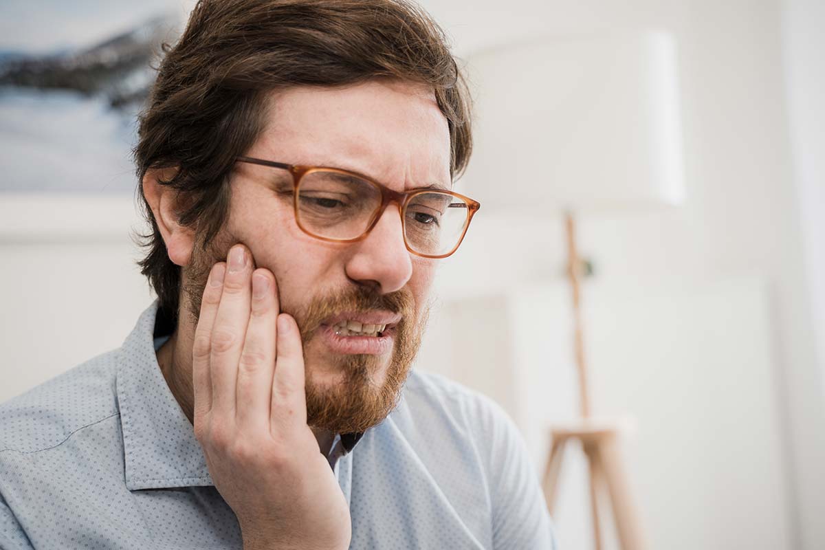 man holding jaw needing dental appointment