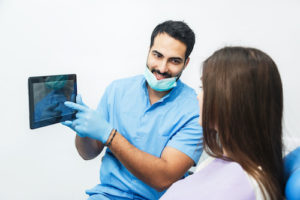 man explaining what a root canal treatment is to a patient 